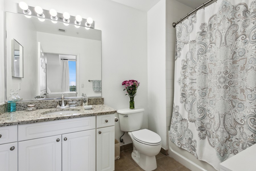 Real Estate Photography - 255 Evernia St, Unit 403, West Palm Beach, FL, 33401 - Primary Bathroom Brighten flowers eliminate robe